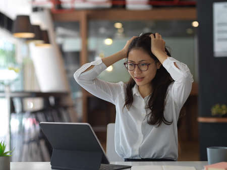 Stressed young businesswoman upsetting about the project while working in the office room