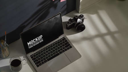 Top view of worktable with laptop, camera, coffee mug and copy space