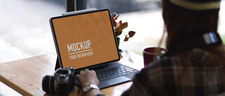 Cropped shot of young woman working with mock up tablet in comfortable workspace