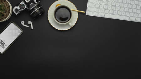 Top view of workspace with smartphone, coffee cup, camera, earphone and copy spaceの写真素材