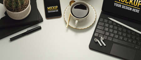 Top view of workspace with tablet, smartphone, coffee cup, accessories and copy space