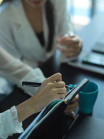 Cropped shot of female office workers consulting on their project with digital tablet in meeting...