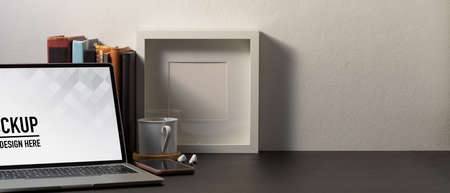 Close up view of workspace with laptop, mock up frame, coffee cup and copy space, clipping path