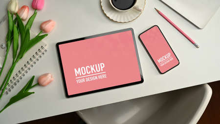 Top view of tablet, smartphone, stationery, coffee cup and flower decorated on the table,の写真素材