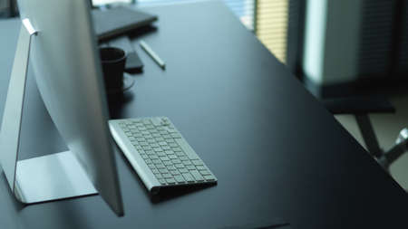 Cropped shot of computer desk with supplies and copy space in office roomの写真素材