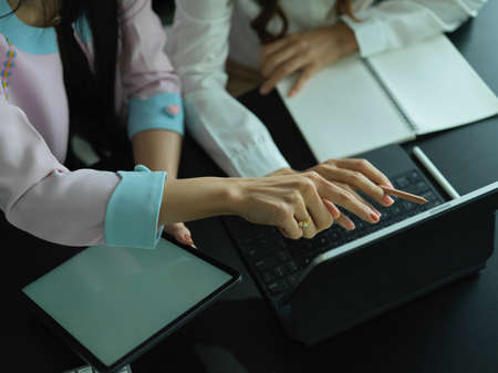 Cropped shot of two female consulting on their project, pointing on digital tablet screenの写真素材