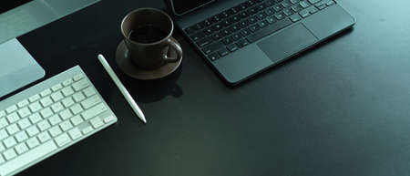 Top view of office desk with computer keyboard, laptop keyboard, coffee cup and copy spaceの写真素材