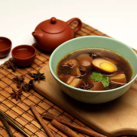 Cropped shot of sweet brown stewed eggs soup (Kai Palo) with pork on bamboo placemat, Thai foodの写真素材
