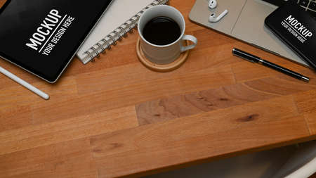 Top view of wooden table  copy space, coffee cup, tablet, smartphone, laptop and stationery,