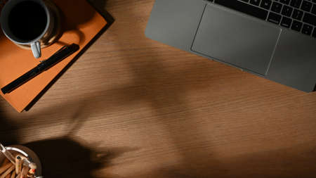 Top view of workspace with workspace with laptop, stationery, cup and copy space on the tableの写真素材