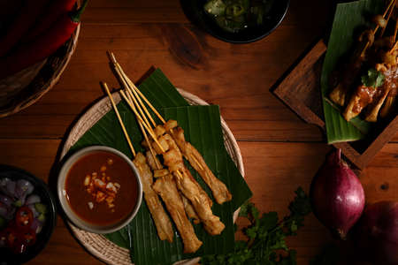 Top view of Grilled pork satay (Moo Satay) served with peanut sauce on the table, Asian street foodの写真素材