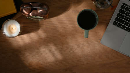 Top view of workspace with laptop, coffee cup, decorations and copy space on wooden tableの写真素材