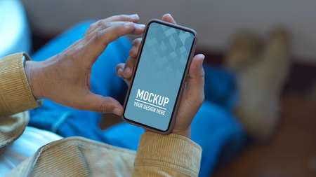 Close up view of male using smartphone while relaxed sitting in office room,