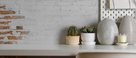 Close up view of worktable with copy space, plant pot and decorations in home office roomの写真素材