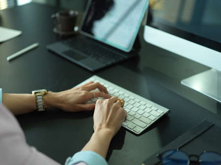 Close up view of businesswoman hands typing on computer keyboard on office deskの写真素材