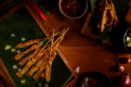 Top view of Grilled pork satay (Moo Satay) served with peanut sauce on the table, Asian street foodの写真素材