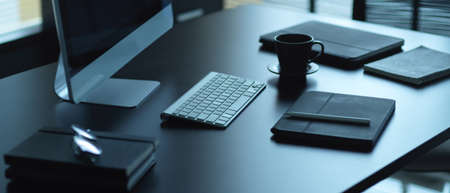 Cropped shot of office desk with computer, supplies and coffee mug in office room