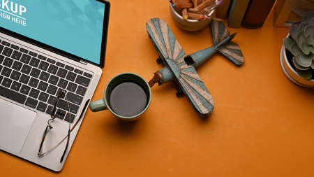 Top view of workspace with laptop, coffee mug, decorations and copy space in home office