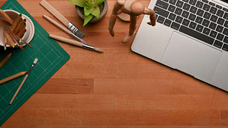 Top view of workspace with laptop, stationery, decorations and copy space on wooden table