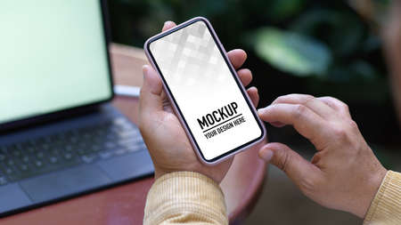 Close up view of male hand using smartphone while working with tablet in garden, include clipping...