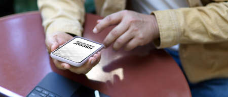 Close up view of male hands using smartphone on coffee table in garden, include clipping path