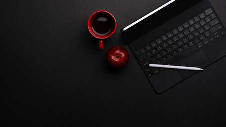 Top view of workspace with tablet, keyboard, stylus, coffee mug and copy space in home office roomの写真素材