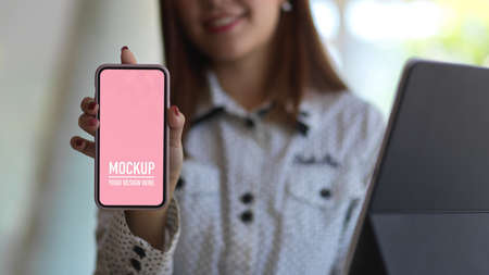 Close up view of female showing smartphone screen, include clipping path
