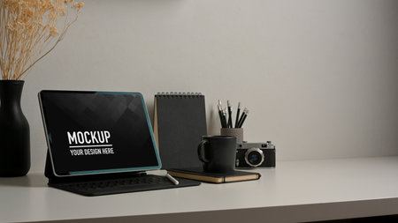 Cropped shot of home office desk with tablet, stationery, camera and decorationsの写真素材