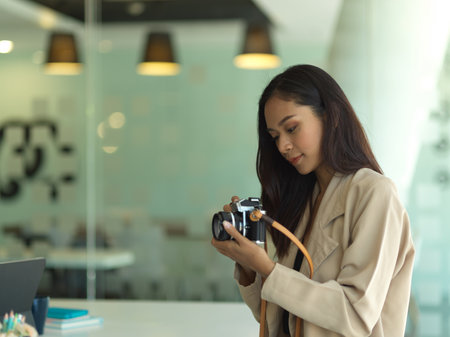 Portrait of female photographer working with camera in her studio