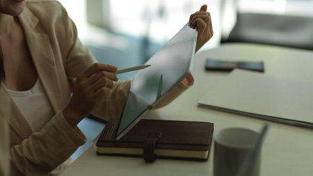 Side view of businesswoman working with tablet on worktable in office roomの写真素材
