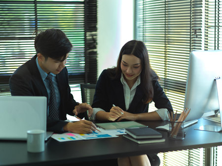 Portraits of businesspeople working together with paperwork and office supplies  in office roomの写真素材