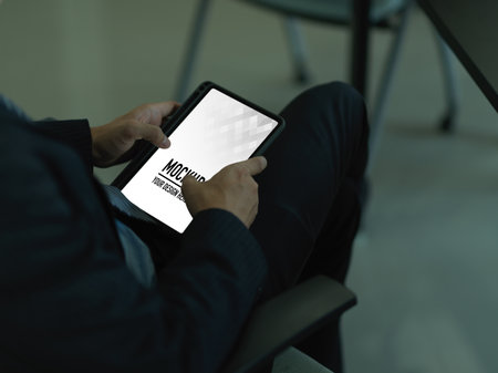 Cropped shot of businessman using digital tablet while relaxed sitting in office room, clipping pathの写真素材