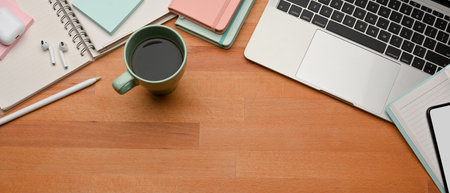 Top view of workplace with laptop, coffee cup, stationery and copy space in home office room