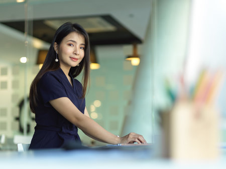Portrait of businesswoman smiling to camera while working in office roomの写真素材