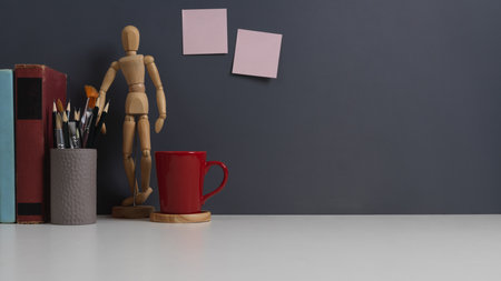 Close up view of workspace with paint tools, stationery, books, mug and copy space in home office roomの写真素材