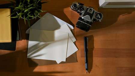 Top view of workspace with mock up cards, camera, stationery, books and copy space in home office roomの写真素材