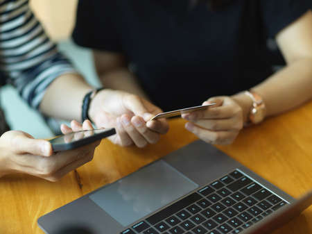Close up view of businesspeople hands using smartphone and credit card to online baking