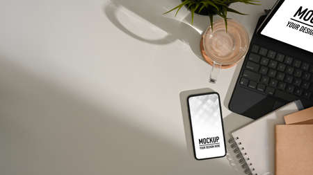 Top view of worktable with smartphone, tablet, notebooks, coffee cup and copy space, clipping path