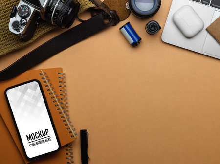 Top view of workspace with smartphone, camera, accessories and copy space in home office room