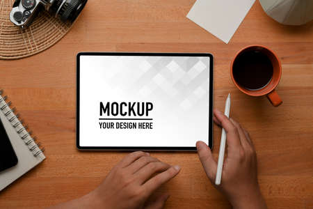 Top view of male hand working with digital tablet include clipping path on wooden tableの写真素材