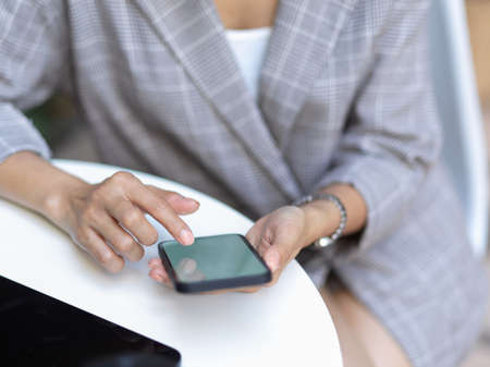 Top view of female hand using smartphone while takes short time-out in office work