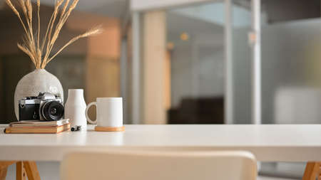 Close up view of worktable with camera, stationery, plant vase and copy space on the table in living roomの写真素材