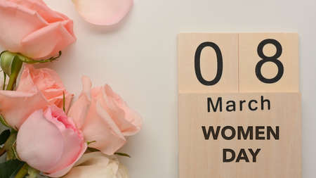 8 March Women's day on white table background decorated with pink roses