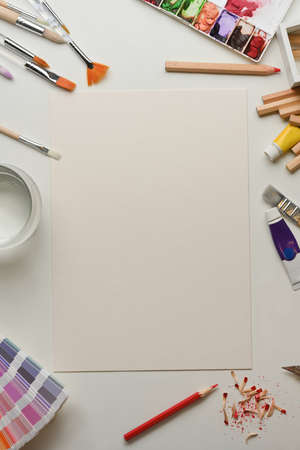 Top view of creative flat lay artist workspace with mock up paper and paint tools in home office roomの写真素材