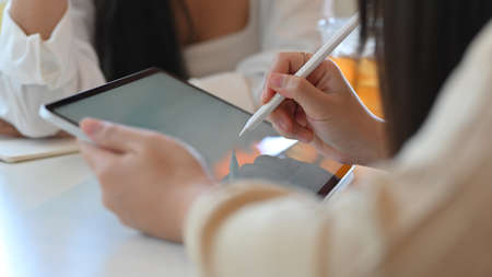 Cropped shot of young businesswomen discussing their project together while using mock up tablet