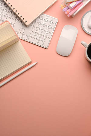 Cropped shot of pink creative study table with computer keyboard, mouse, stationery and copy spaceの写真素材