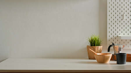 Home interior design with mixed bowl, coffee pot, mug, plant pot and copy space on kitchen tableの写真素材