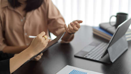 Cropped shot of two businesswomen working with digital tablet and discussing on their workの写真素材