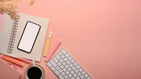 Pink creative study table with smartphone, computer keyboard, coffee cup and school elements, top view, clipping pathの写真素材