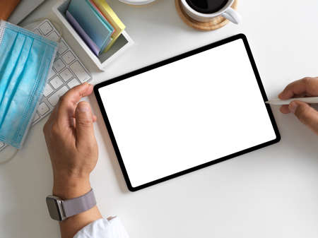 Overhead shot of businessman using digital tablet tablet with mock up screen on workspace, clipping...
